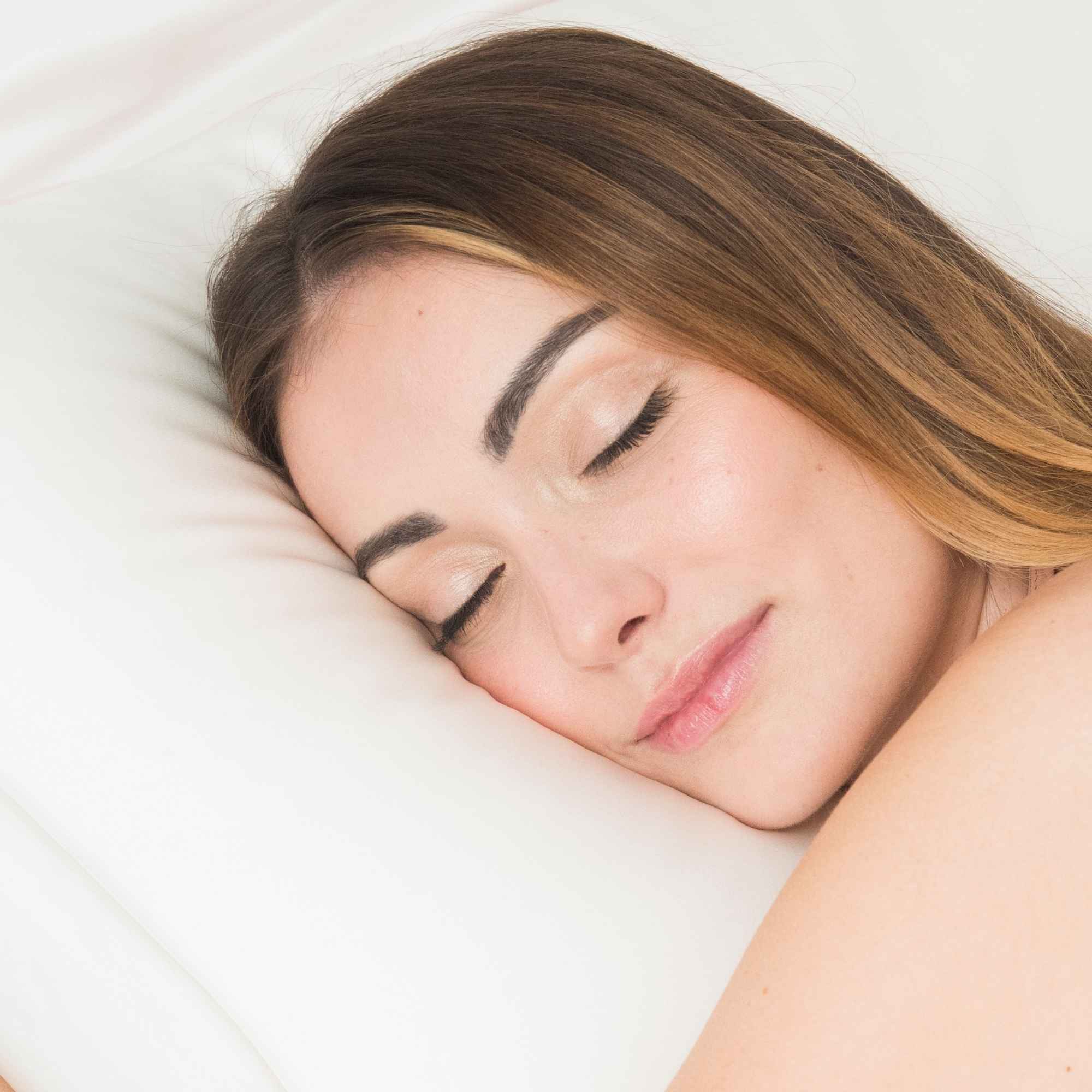 Femme dormant paisiblement sur une taie d’oreiller en soie blanche Made in France SILKBIOTIC.