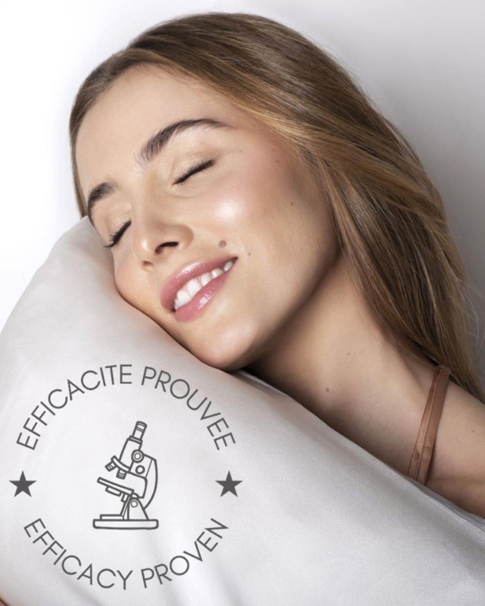 Femme reposant sur une taie d'oreiller en soie SILKBIOTIC avec logo d'efficacité prouvée.