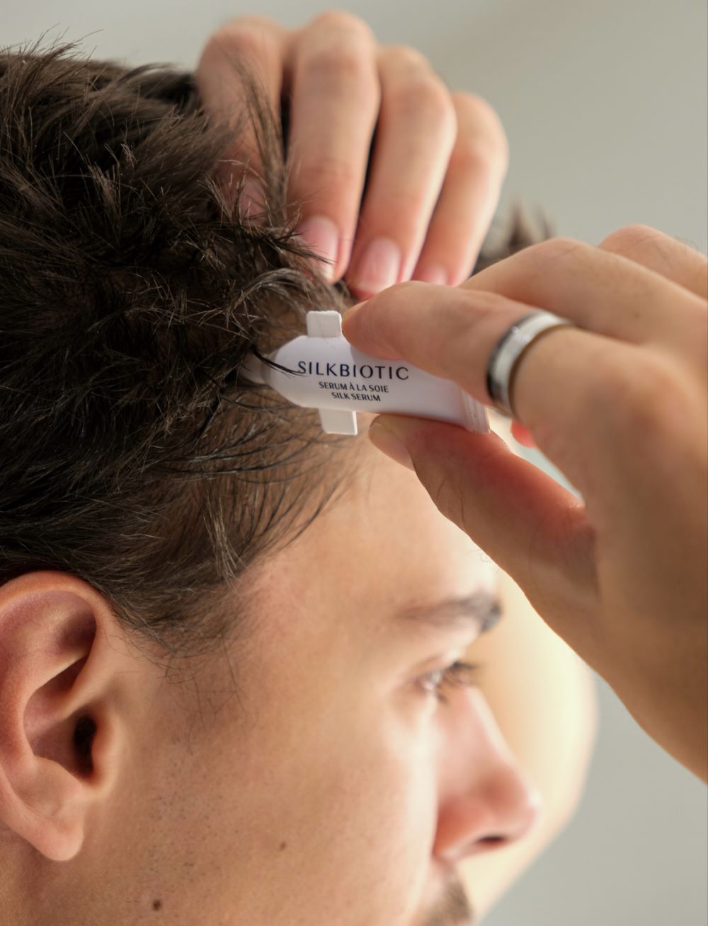 Application du sérum cuir chevelu Silkbiotic sur les cheveux d'un homme.
